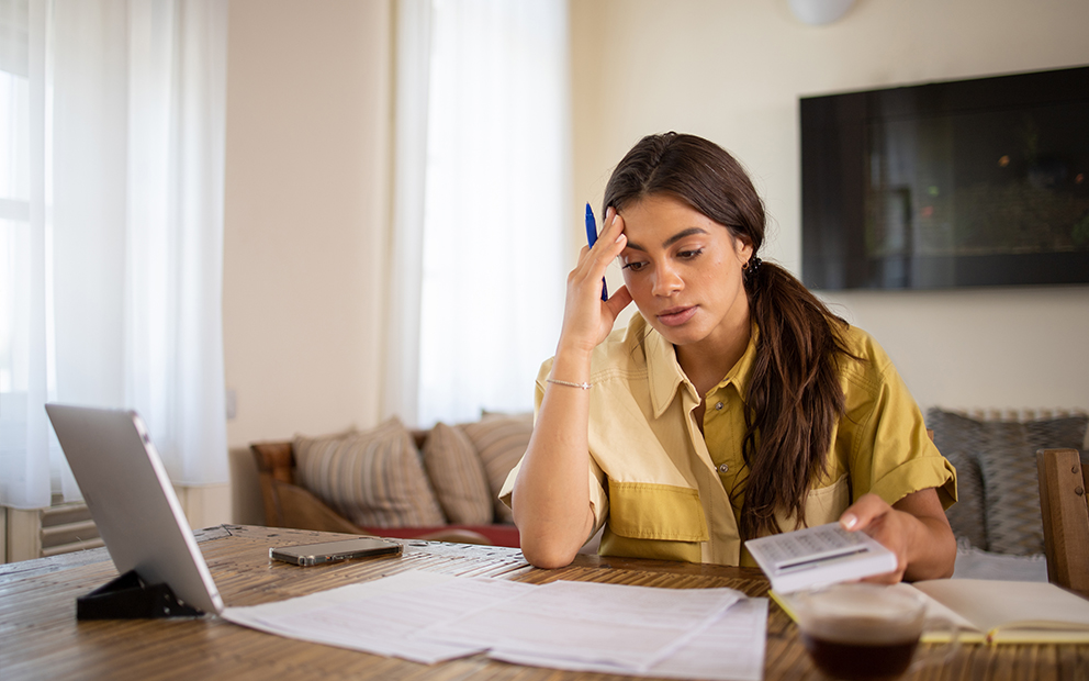Woman looking stressed while review finance documents at home