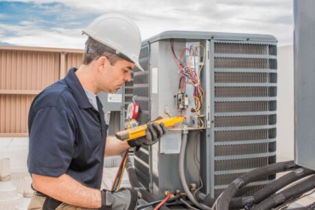 Professional inspecting unit on roof to determine when to service your HVAC system