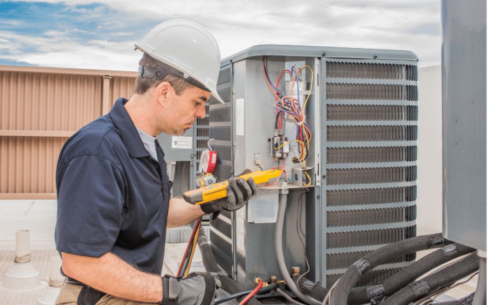 Professional inspecting unit on roof to determine when to service your HVAC system