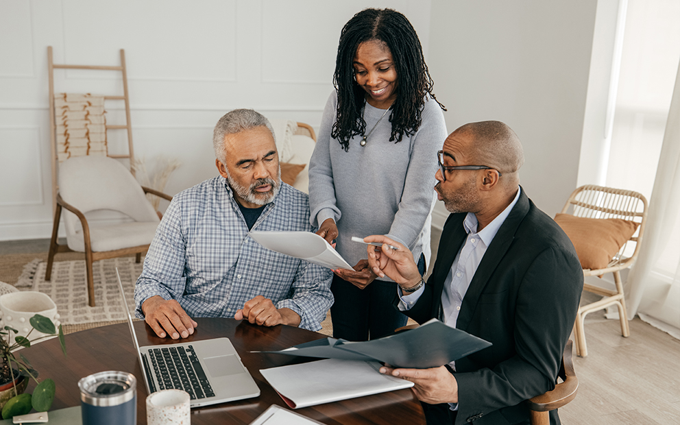 Couple speaking with realtor over financial documents