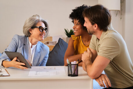 Younger couple speaking with mortgage banker at home
