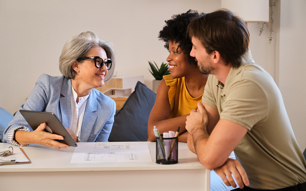 Younger couple speaking with mortgage banker at home