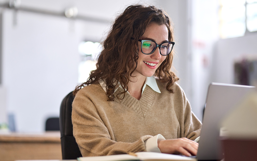 Women smiling while researching on laptop