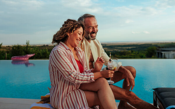 Couple relaxing on deck outside after buying a summer home