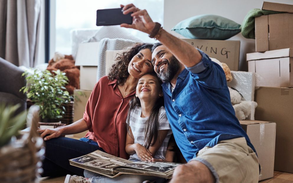 VA loan co-borrower and his wife and child taking a selfie on floor of new home living room