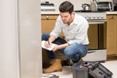 Homeowner inspecting appliances to calculate unexpected home repair costs
