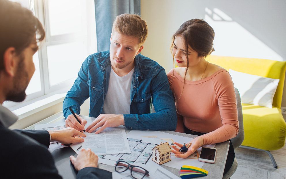 Couple speaking with planner on best time to build a home