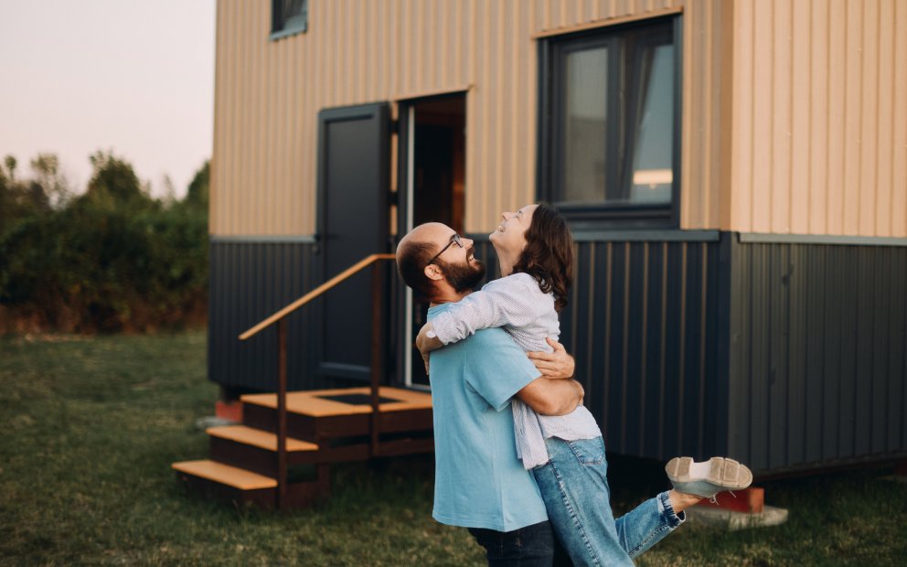 Man and woman couple hugging after using va loan for tiny home