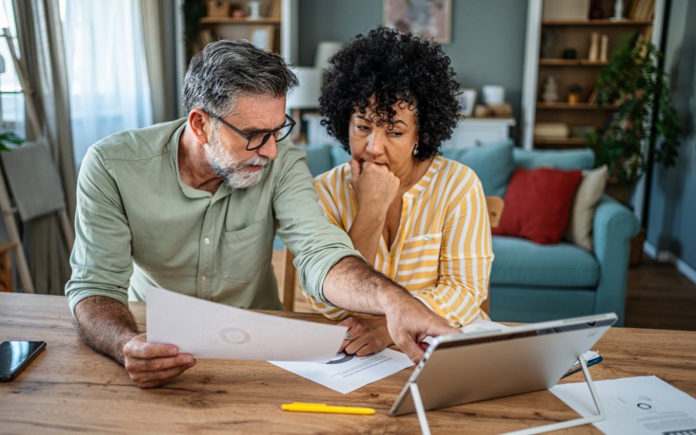 Older man and woman couple sitting together at home looking into what is an end loan
