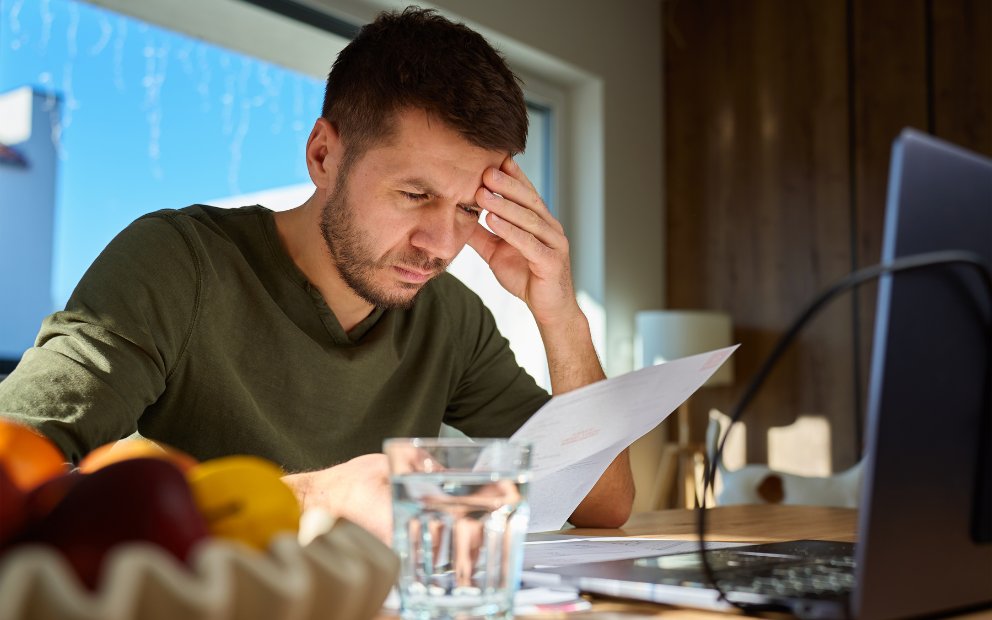 Man sitting at home desk trying to learn about his negative home equity