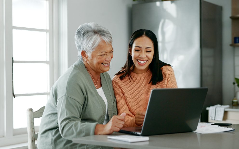 Older woman looking over laptop with younger woman to find what do people use home equity for