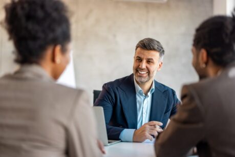 Advisor explaining digital mortgage process to young couple