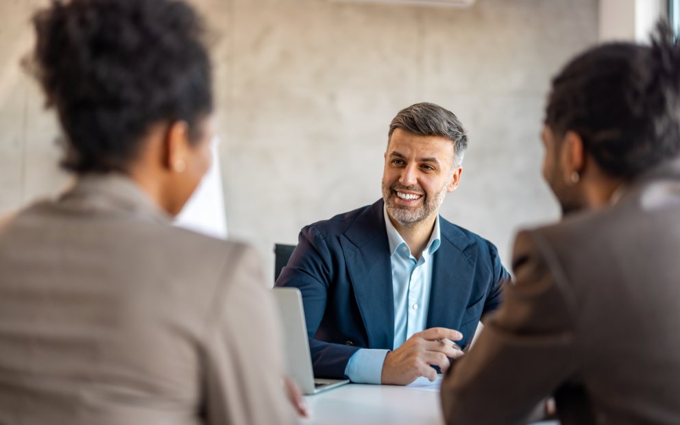 Advisor explaining digital mortgage process to young couple