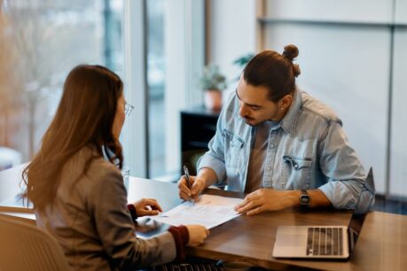 Young man signing contract to obtain fha duplex loan