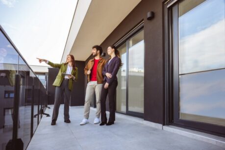 Young man and woman couple looking at using a jumbo condo loan with realtor