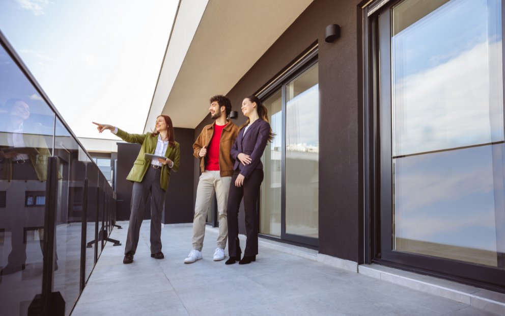 Young man and woman couple looking at using a jumbo condo loan with realtor