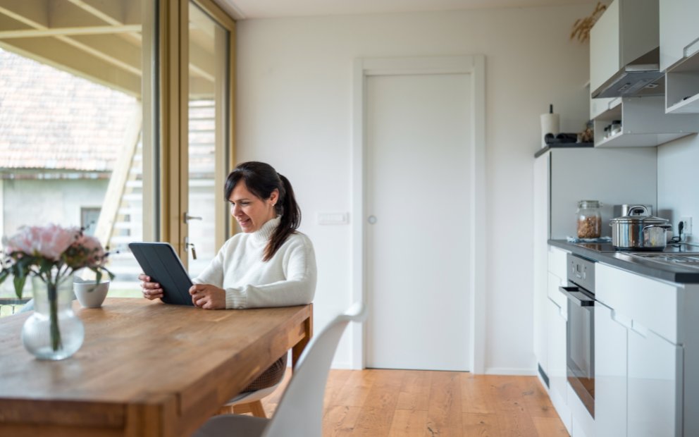 Woman in home kitchen reviewing online options for fha manufactured home loan
