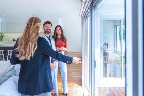 Young man and woman couple touring home while weighing conforming vs jumbo loan