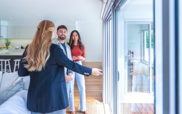 Young man and woman couple touring home while weighing conforming vs jumbo loan