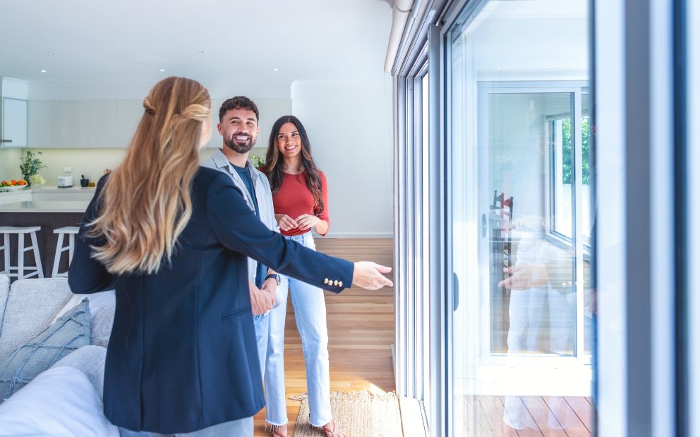 Young man and woman couple touring home while weighing conforming vs jumbo loan