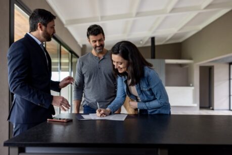 Young man and woman adult couple signing lease for conventional loan duplex
