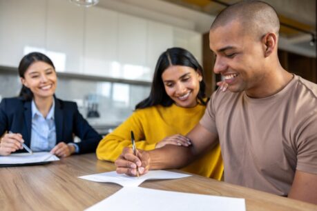 Young man and woman couple sitting with an agent as they discuss a Fsbo va loan
