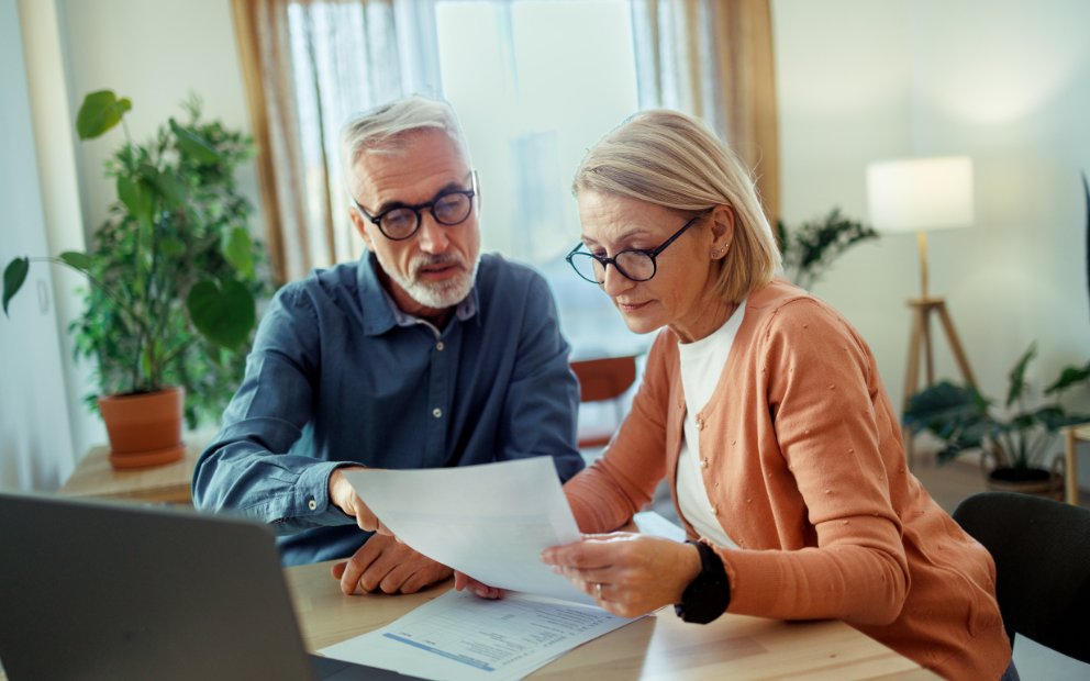 Older couple sitting together at home looking into a first lien heloc