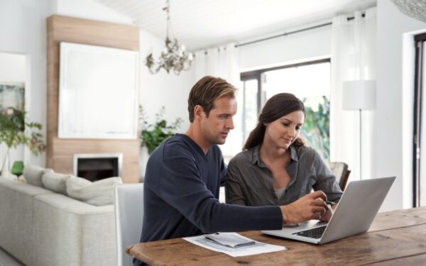 Young man and woman couple sitting together at home while they research when to use home equity