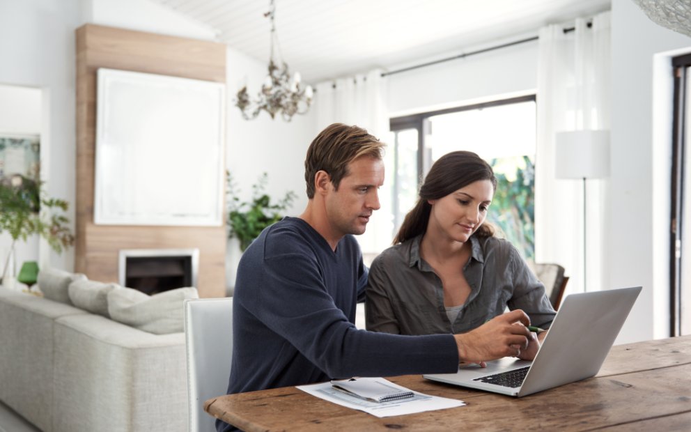 Young man and woman couple sitting together at home while they research when to use home equity