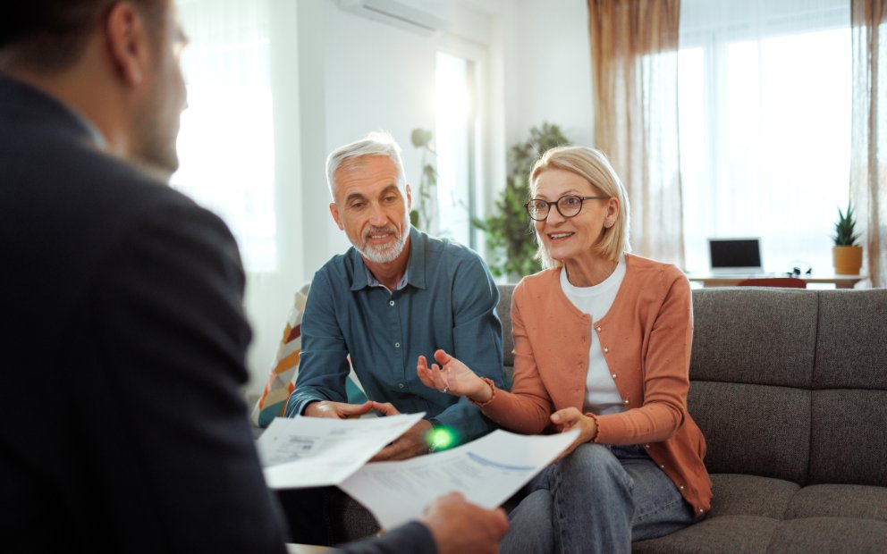 Older man and woman couple speaking to advisor about Retirement home financing