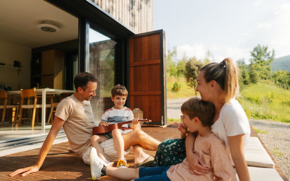 Young man and woman couple with their two kids asking Is a second home worth it