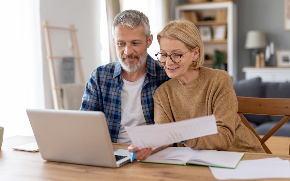 Older man and woman couple looking into how to use home equity to buy land