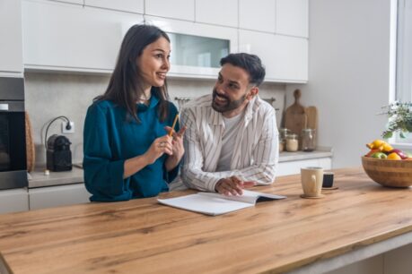 Young couple at home looking into home equity loan for wedding