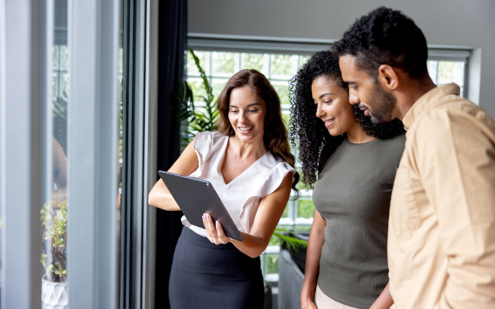 Young couple speaking with realtor at new home after taking fha self sufficiency test