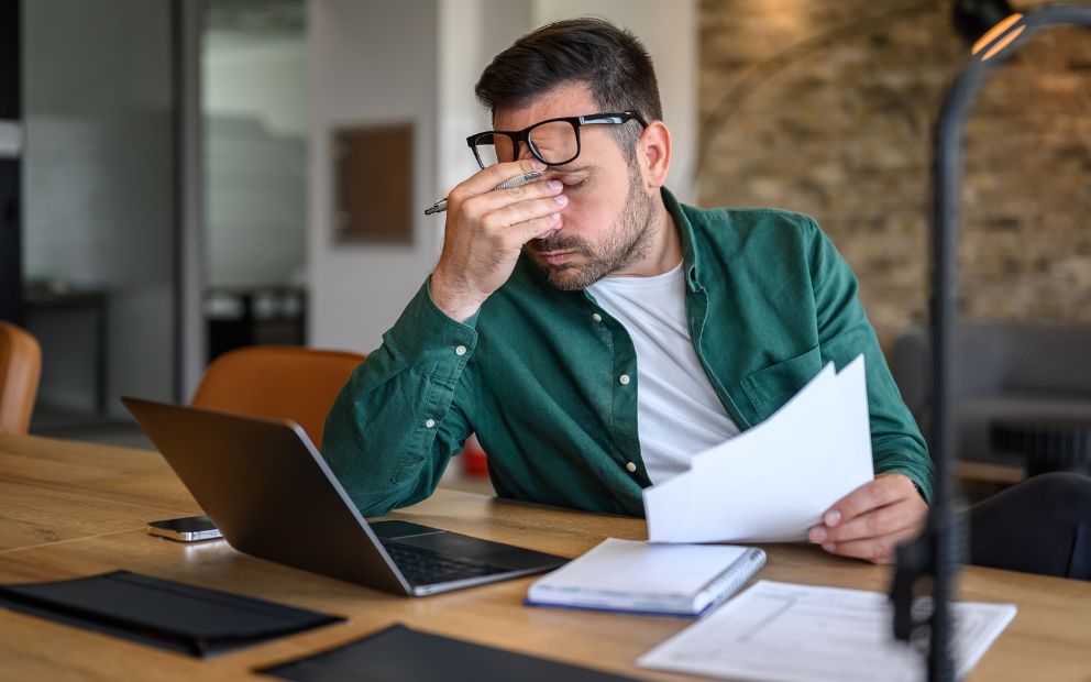 Man at home looking frustrated as he experiences decision fatigue when building a home