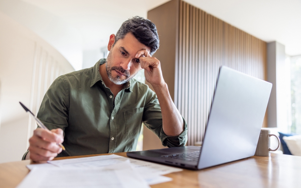 Middle-aged man at home researching homebuying mistakes to avoid