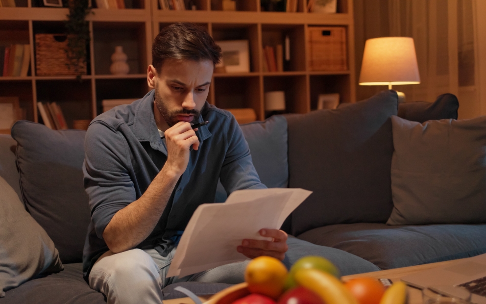 Man sitting alone at home reading up on buying a haunted house