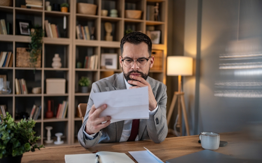 Man sitting at home desk researching what happens to a HELOC when you sell your home