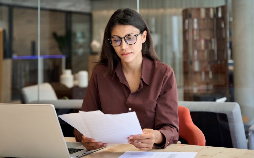 Woman at home reviewing documents regarding her Mortgage servicer